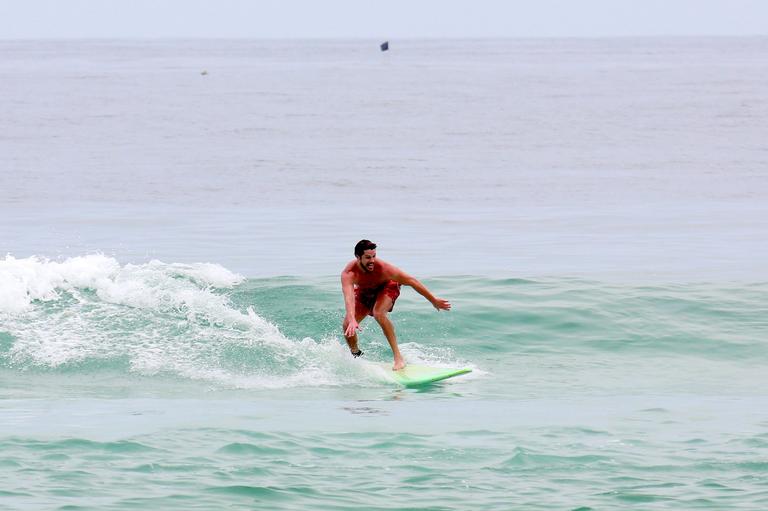 Cauã Reymond e José Loreto surfam em praias cariocas