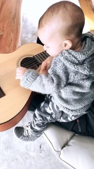 Junior Lima mostra Otto, de 5 meses, brincando com o violão