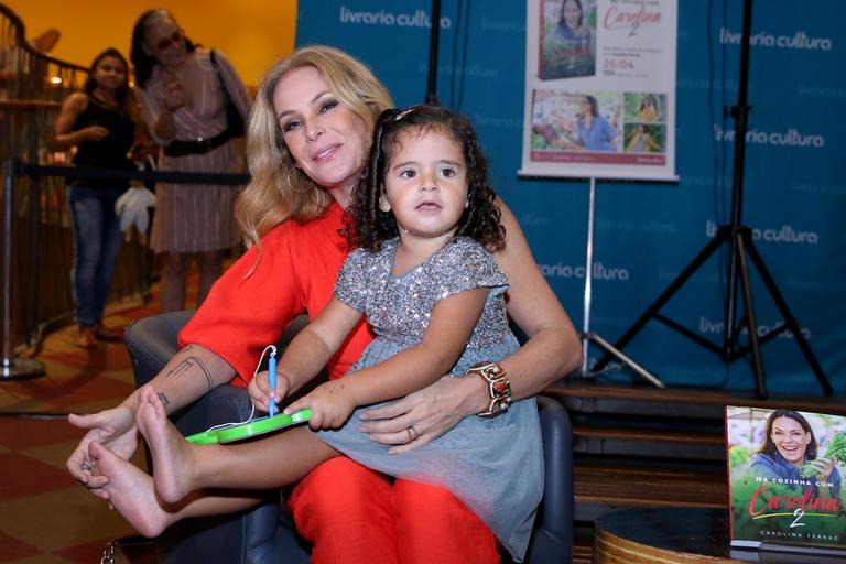 Carolina Ferraz recebe o carinho da filha em sessão de autógrafos