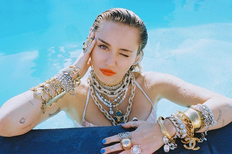 Luxo é pouco! Miley Cyrus posa com kilos de joias na piscina