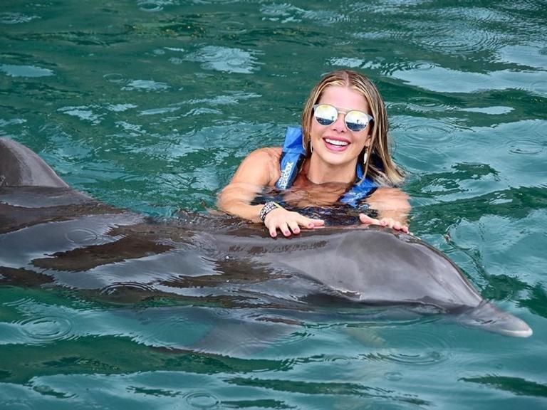 Karina Bacchi e a família nadando com os golfinhos 