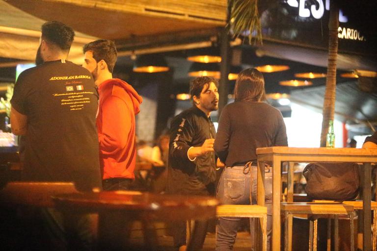 Sem máscara, Douglas Sampaio é flagrado com amigos em bar