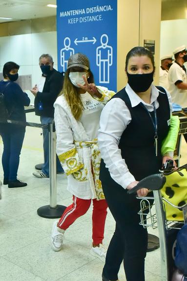 Após temporada na Europa, Anitta desembarca de roupão no Brasil