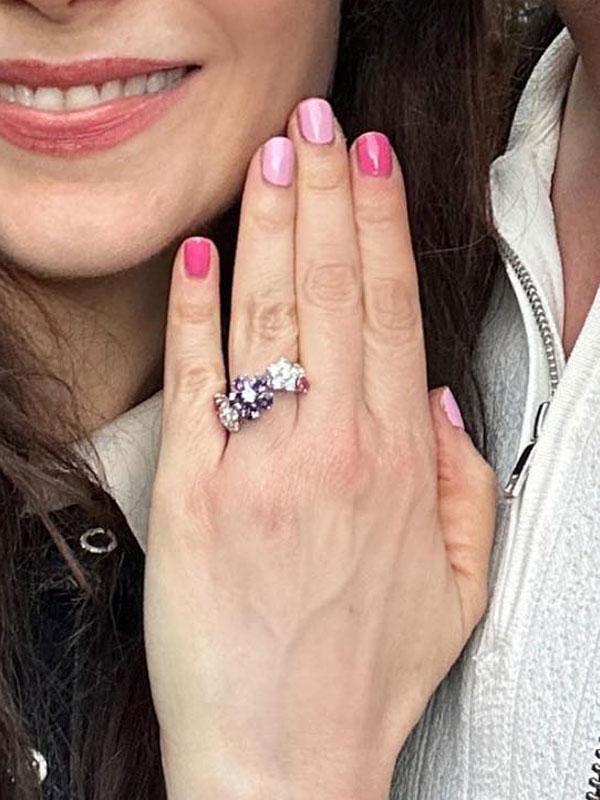anel de noivado na mão de Zooey Deschanel